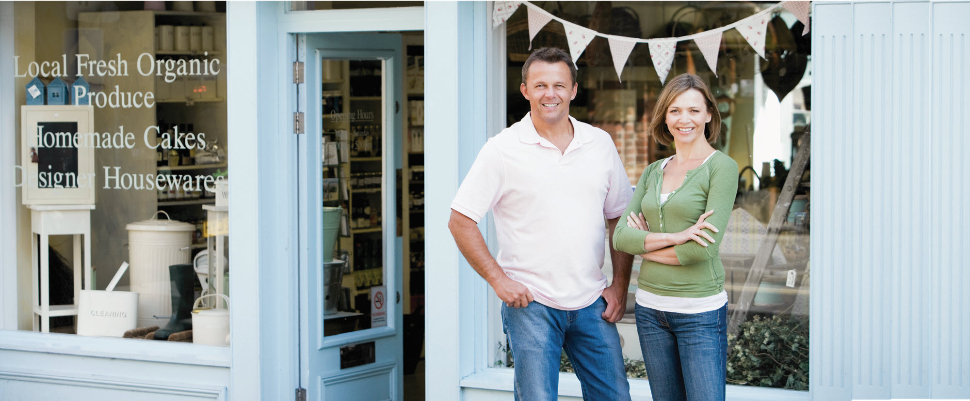 two business owners standing in front of their store