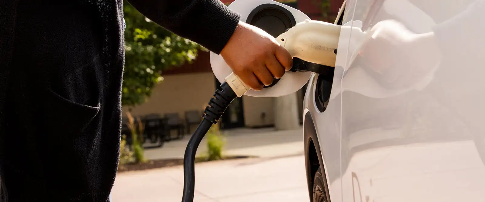 Someone plugging in an electric vehicle